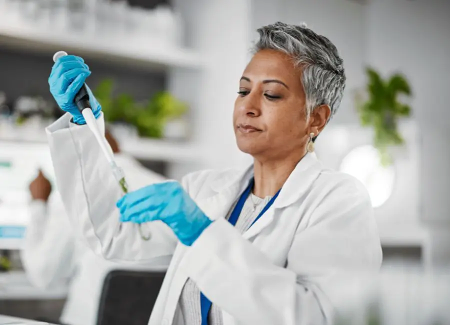 Scientist using a pipette to analyze food samples for calorie calculation and nutritional testing in a modern laboratory.