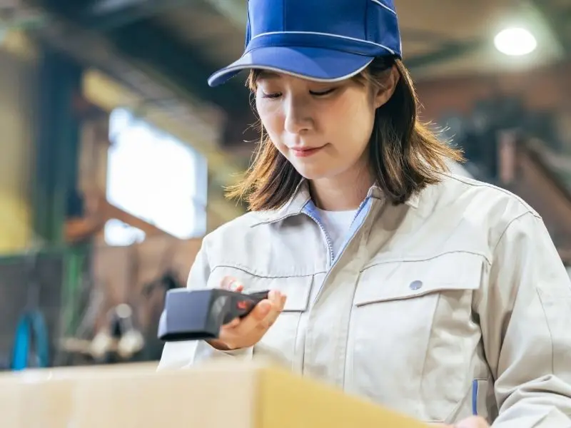 Worker scanning barcode on food package for traceability and inventory tracking in a warehouse environment