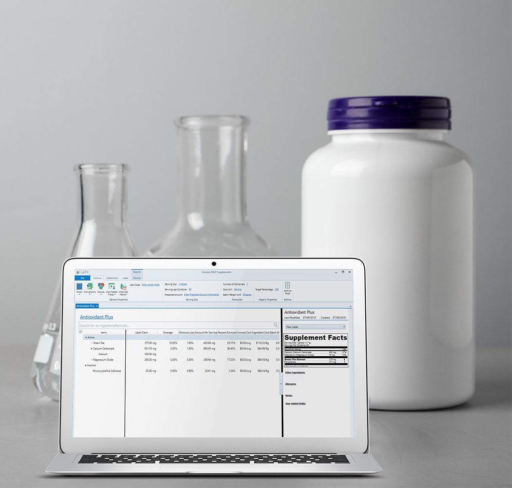 A laptop showing the Genesis Supplements formulation and labeling software, with beakers and a product package behind the laptop.