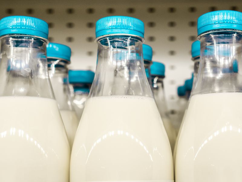 Close-up of milk bottles with blue caps, highlighting dairy allergen labeling per FDA guidelines